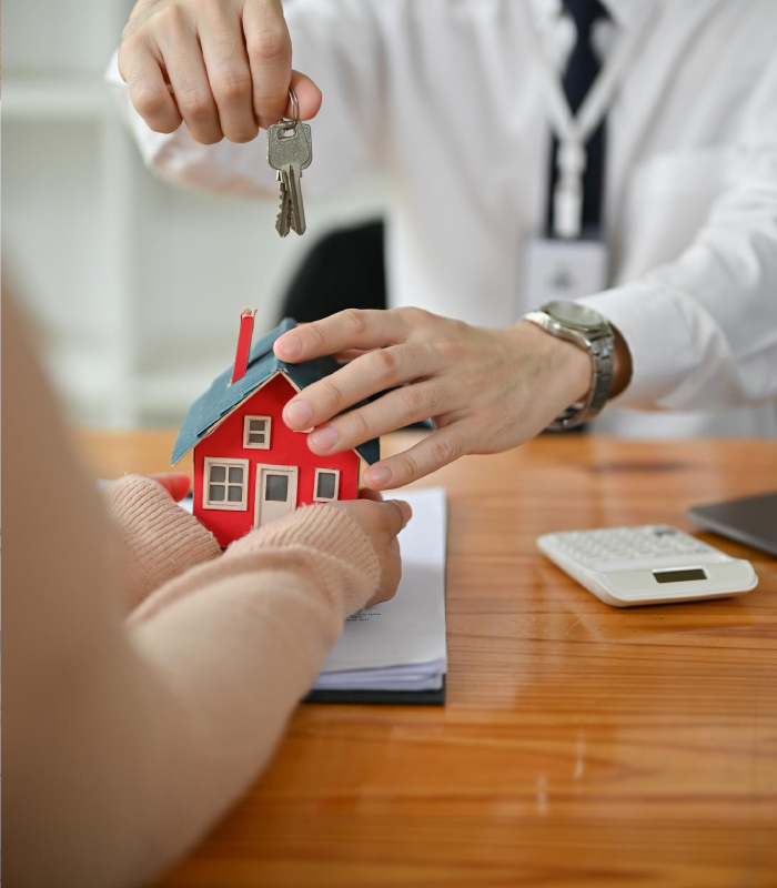Maquette de maison et trousseau de clés posés sur un plan, visuel pour estimation immobilière et vente avec L’Avenue